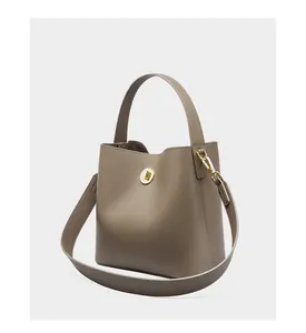 Dettaglio della borsa a secchiello in pelle taupe con fibbia in metallo dorato