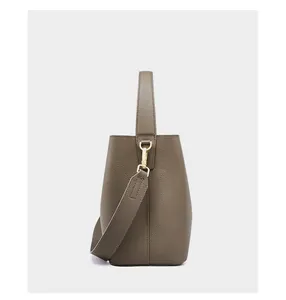 Vista laterale dettagliata della borsa a secchiello in pelle marrone con hardware oro