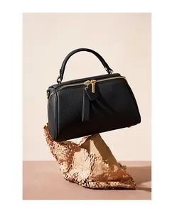 Close-up of black litchi grain cowhide leather Boston bag with gold zipper and handle