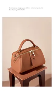 Detailed macro view of caramel lychee grain leather Boston bag with golden zipper hardware