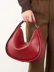 Minimalist deep red crescent crescent shoulder bag with silver buckle and top handle