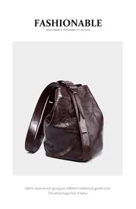 Nahaufnahme der Retro-Faltenstruktur der dunkelbraunen Leder-Beuteltasche mit Riemen