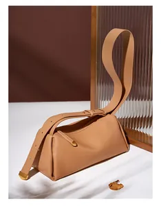 Détail du sac polochon en cuir camel avec bandoulière large et finition mate