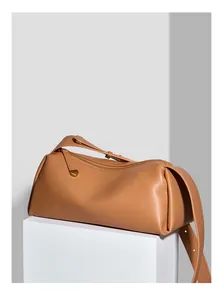 Détail du sac polochon en cuir camel avec une tirette de fermeture éclair en forme de cœur