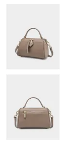 Taupe pebbled leather Boston bag detail with golden zippers and adjustable strap