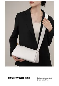 Sac à bandoulière en cuir blanc en forme de noix de cajou sur une veste noire