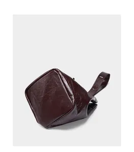 Makro-Detail der dunkelbraunen Leder-Beuteltasche mit weicher Faltenstruktur und Finish