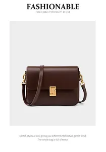 Close-up of geometric gold metal buckle on dark brown leather crossbody bag