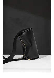 Détail de la texture cuir noir grainé et de la fermeture éclair dorée de luxe du sac