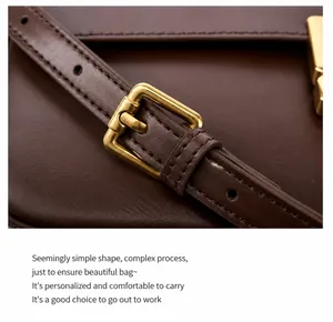 Detailed close-up of premium brown leather texture and golden metal buckle of a crossbody bag