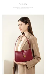 Détail d'un sac à main en cuir rouge foncé avec une boucle Wulu dorée pour femme chic