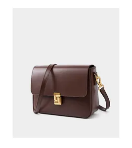 Detail view of smooth dark brown leather texture and golden geometric metal buckle