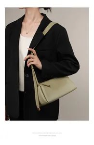 Détail du sac en cuir vert sauge avec côtés plissés élégants et fermeture goutte d'eau