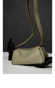 Détail macro du sac oreiller en cuir gris-vert avec matériel doré et bandoulière large