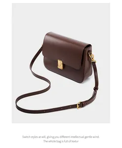 Detail of vintage brown leather handbag featuring a polished gold geometric metal buckle