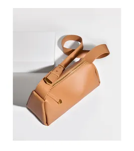 Détail du sac polochon en cuir marron souple avec bandoulière large et métal doré