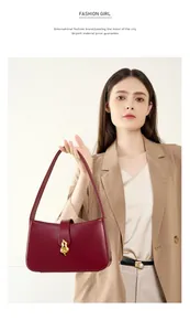 Gros plan sur un sac sous le bras en cuir rouge avec boucle métallique dorée en gourde