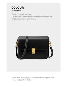 Close-up of black leather crossbody bag featuring a golden square clasp and metal hook