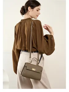 Détail du sac en cuir taupe avec fermoir rotatif doré et fine bandoulière réglable