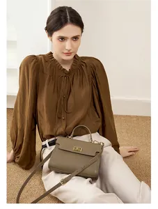 Gros plan d'un sac à main classique en cuir avec fermoir doré et bandoulière réglable