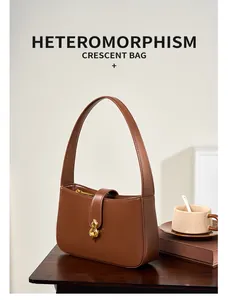 Gros plan d'un sac demi-lune en cuir marron avec boucle métallique dorée chic