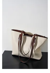 Détail du sac cabas en cuir beige avec anses marron foncé et fermeture éclair