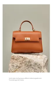 Vue détaillée du cuir Saffiano marron et du fermoir rotatif doré de ce sac à main