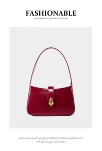 Détail macro d'un sac sous les aisselles en cuir rouge vin avec boucle dorée en gourde