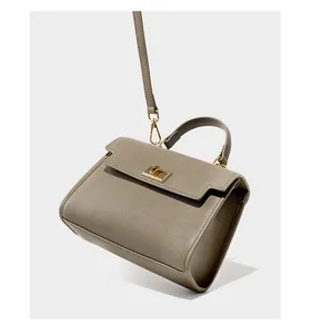 Détails du cuir Saffiano taupe et du fermoir doré rotatif sur le sac trapèze chic