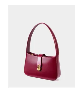 Gros plan détaillé du sac en cuir rouge foncé avec fermoir doré élégant et texture lisse