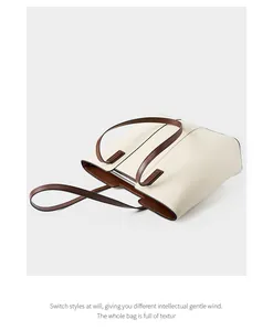 Détail d'un grand cabas bicolore en cuir beige avec des poignées marron élégantes