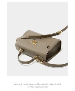 Détail de la texture cuir grainé et du fermoir doré sur le sac à main en cuir