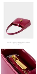 Vue détaillée de la texture du sac en cuir bordeaux avec fermeture éclair dorée et fermoir