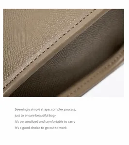 Gros plan sur le grain du cuir marron et les coutures renforcées de ce sac à main