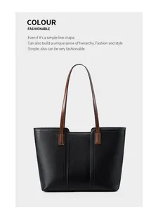 Détail du sac cabas en cuir noir grainé avec des bandoulières en cuir lisse marron