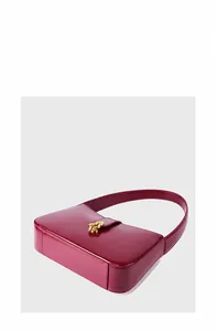 Détail d'un sac à bandoulière en cuir magenta avec une boucle dorée élégante