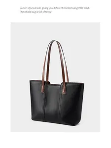 Détail du sac cabas en cuir grainé noir avec anses marron et coutures verticales