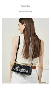 Close-up of black oil wax leather baguette bag with a gold triangle metal logo buckle