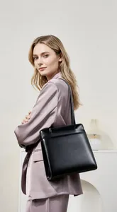 Model wearing a premium black leather tote bag with elegant slender shoulder straps