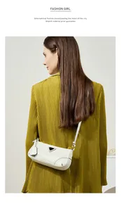 Close-up of ivory oil wax leather shoulder bag with iconic metal logo on mustard jacket