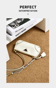 Detailed view of white leather shoulder bag with black trim and triangle plaque