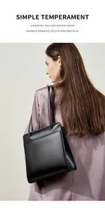 Détail d'un sac cabas structuré en cuir noir porté par un mannequin en blazer.