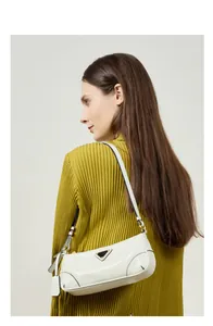 Detail of white oil wax leather baguette bag featuring triangle logo and adjustable strap