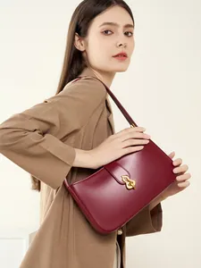 Sac sous le bras élégant en cuir rouge vin pour femme avec fermoir doré en studio