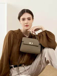 Sac Kelly en cuir vert olive avec garniture dorée porté en bandoulière pour femme