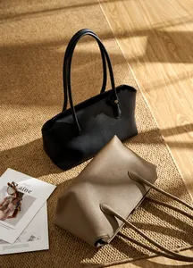 Dettaglio della trama in pelle di litchi premium su borse tote nere e marroni eleganti