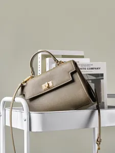 Sac à main classique en cuir camel foncé avec fermoir doré sur un chariot blanc élégant