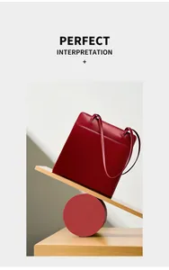 Mise en scène artistique d'un sac cabas en cuir rouge sur planche de bois