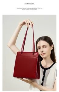 Détail du sac cabas en cuir rouge montrant la texture mate et le design de la bandoulière