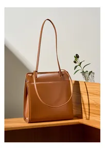Détail d'un cabas en cuir marron avec poche avant fonctionnelle sur présentoir en bois